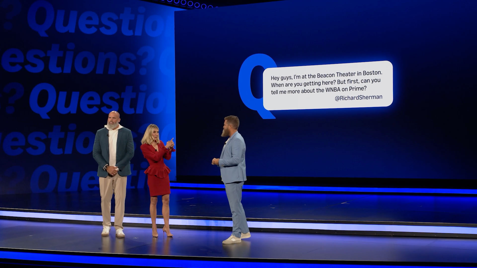 Three presenters beside repeated Questions lettering and a large blue question bubble.